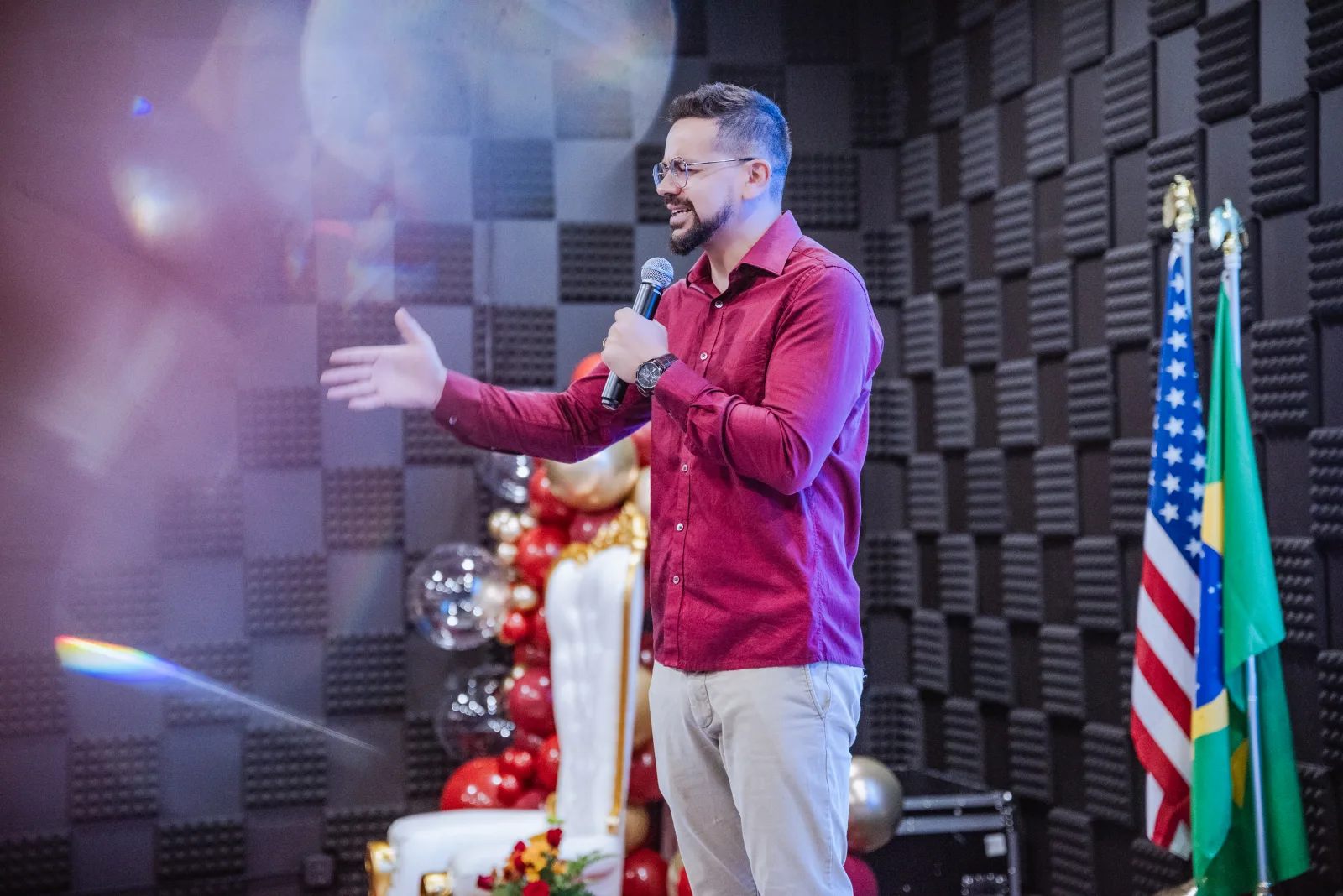 David Borges conduzindo uma palestra no palco durante um encontro presencial